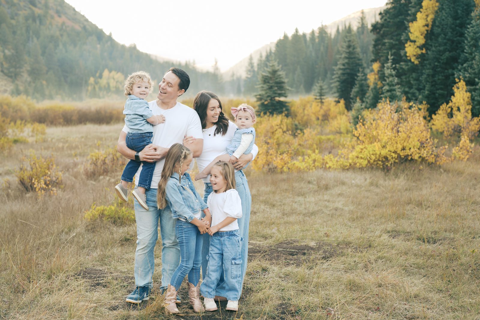 Family of six in white and denim in a fall mountain meadow with golden aspens