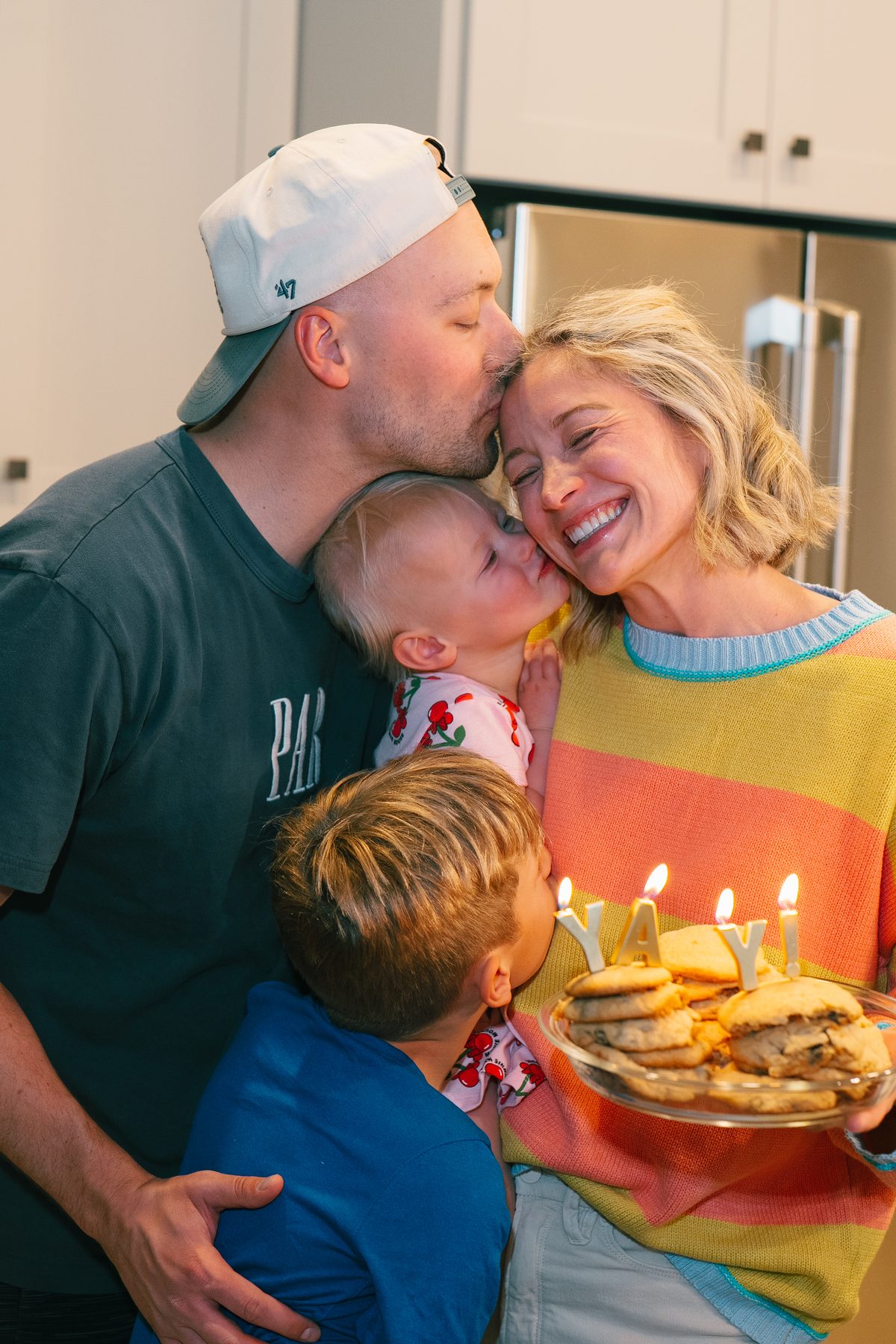 Sami laughing with her family over a plate of birthday cookies and candles